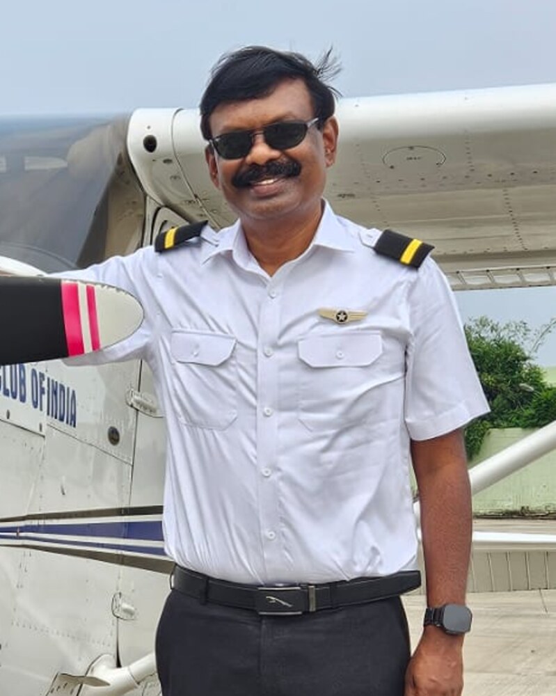 Siddharth in pilot uniform beside a training aircraft